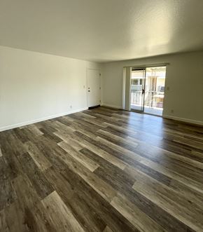 Campbell apartment for rent - an empty living room with wooden floors and a door to a balcony