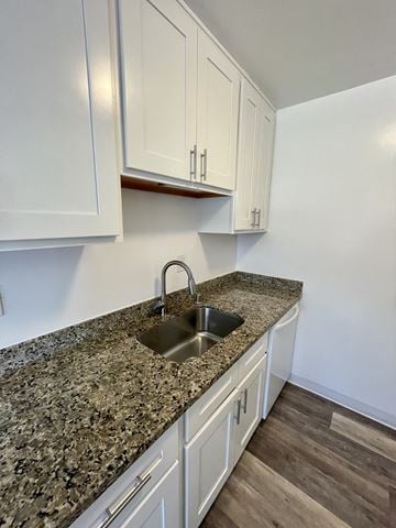 Campbell apartment for rent - a kitchen with white cabinets and granite counter top and a sink