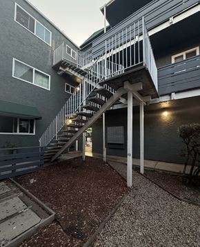 San Jose apartment for rent - A staircase with a metal railing leads up to a building.