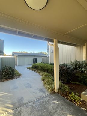 Sunnyvale apartment for rent - A concrete pathway leads to a building with a metal roof.