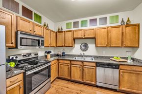 Austin apartment for rent - A kitchen with wooden cabinets and stainless steel appliances. at Agave at South Congress, Texas