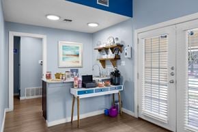Austin apartment for rent - A kitchen area with a table and a shelf with various items on it. at The Arbors at Tallwood, Austin, TX, 78759