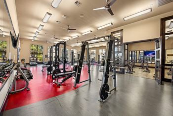 A gym with a variety of equipment including weights and machines.