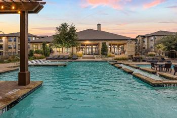 A large outdoor swimming pool with a wooden pergola over it.