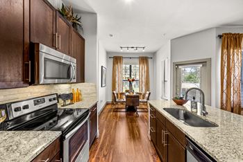 A kitchen with dark wood cabinets and granite countertops.