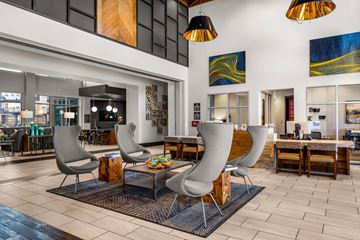 Austin apartment for rent - A modern living room with grey chairs and a wooden coffee table.