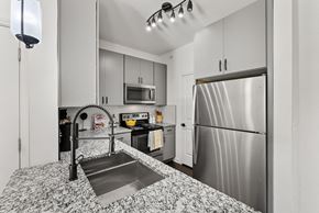Austin apartment for rent - A kitchen with a stainless steel refrigerator and a sink with a black faucet. at Preserve at Rolling Oaks, Austin, TX