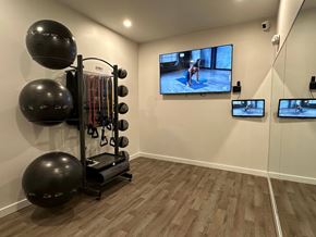 Canton apartment for rent - A home gym with a television screen showing a person exercising.
