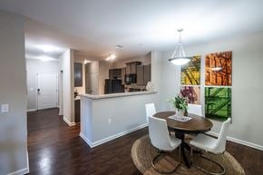 Arden apartment for rent - A dining room with a table set for two and a kitchen area in the background.