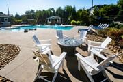 Arden apartment for rent - A poolside area with white chairs and a table.