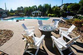Arden apartment for rent - A poolside area with white chairs and a table.
