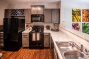 Arden apartment for rent - A kitchen with a black refrigerator and stove.