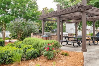 A wooden pergola with a picnic table