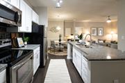 Evans apartment for rent - A modern kitchen with a black refrigerator and stove top oven at Ansley at Town Center Apartments, Georgia