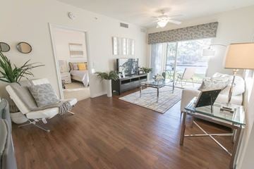 Lake Worth apartment for rent - A living room with a white chair and a glass table.