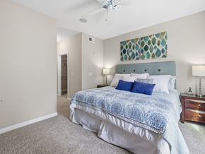 Hardeeville apartment for rent - A bedroom with a bed, nightstand, and a ceiling fan.
