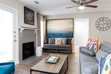 Newnan apartment for rent - A living room with a grey couch and a fireplace.