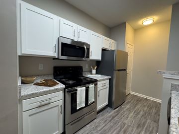 Memphis apartment for rent - A kitchen with white cabinets and a black stove top.