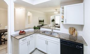 Humble apartment for rent - A kitchen with white cabinets and a black dishwasher.
