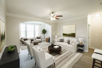 Humble apartment for rent - A living room with a white couch, a coffee table, and a painting on the wall.