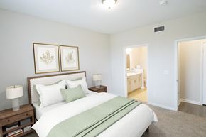 Humble apartment for rent - A bedroom with a large bed and two framed pictures above it.