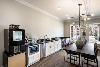 A kitchen and dining room with a table and a television
