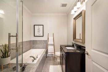 A bathroom with a tub and a sink and a mirror