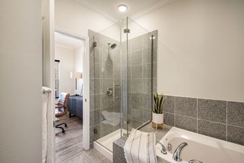 A bathroom with a shower and a tub