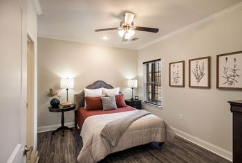A bedroom with a bed and a ceiling fan