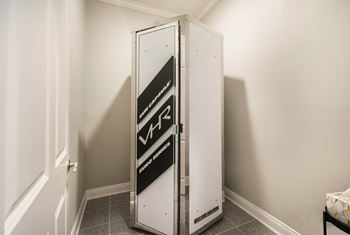 A small refrigerator in a small room in a room with white walls