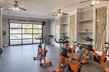 An indoor cardio room with exercise bikes and a window