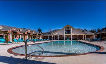 A resort style pool with lounge chairs around it