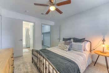 A bedroom with a bed and a ceiling fan