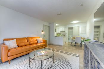 Orange couch and a glass coffee table