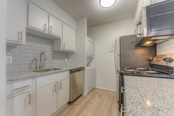 A kitchen with white cabinets and a stove and a refrigerator