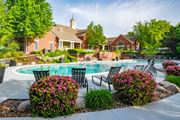 Overland Park apartment for rent - A pool surrounded by a garden with a house in the background. at Cambridge Square, Overland Park
