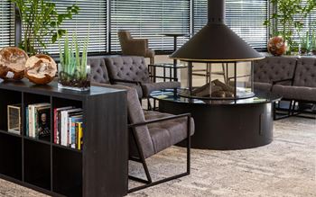A living room with couches and chairs and a table with a lamp