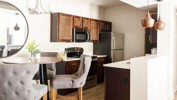 A kitchen and dining room with a table and chairs