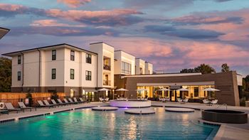 A large swimming pool in front of a hotel