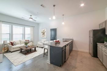 A modern kitchen with a white couch and a wooden coffee table.
