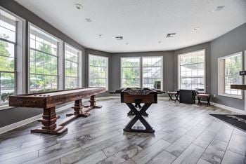 Game room with arcade games, sand shuffle board, and foosball