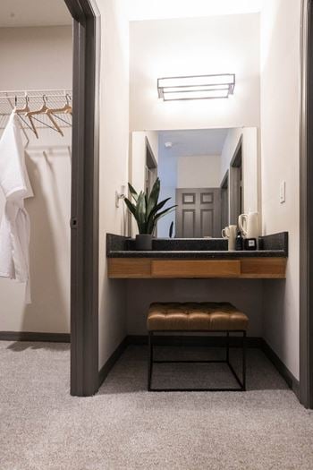 A bathroom with a sink and a mirror and a stool