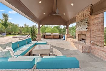 Covered patio with blue couches and a fireplace