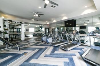 A gym with treadmills, elliptical machines, and other exercise equipment.