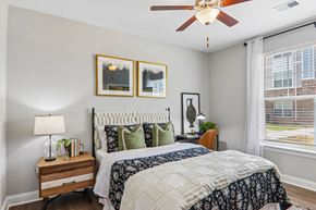 Spartanburg apartment for rent - A bedroom with a large bed and a ceiling fan.