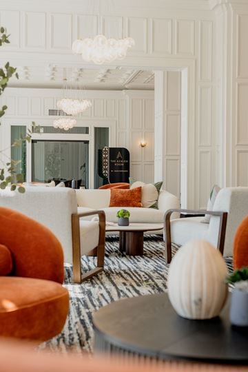 Memphis apartment for rent - A living room with a white sofa, orange armchair, and a coffee table with a white pumpkin on it.