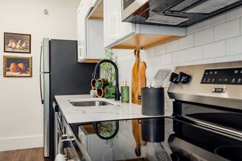 A modern kitchen with a black refrigerator and stainless steel appliances.