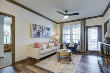 Little Rock apartment for rent - A living room with a white couch and a painting on the wall.