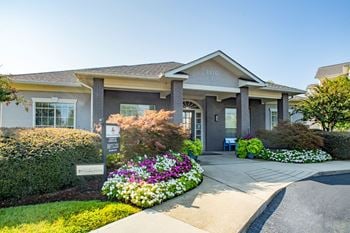 House with flowers and bushes in front of it