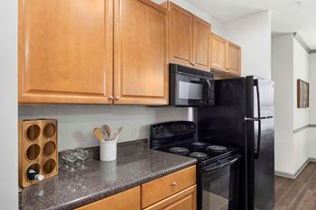 A kitchen with black appliances and wooden cabinets